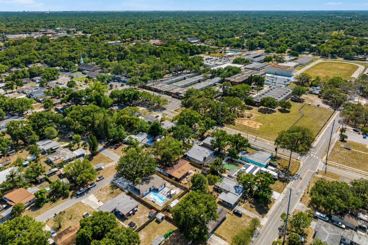A tranquil community unfolds beneath you. Neatly arranged streets are lined with well-kept homes