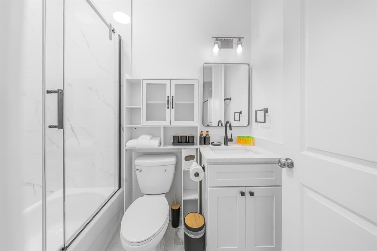 Alternate bathroom view showcasing the glass shower, vanity, and clean, modern layout.