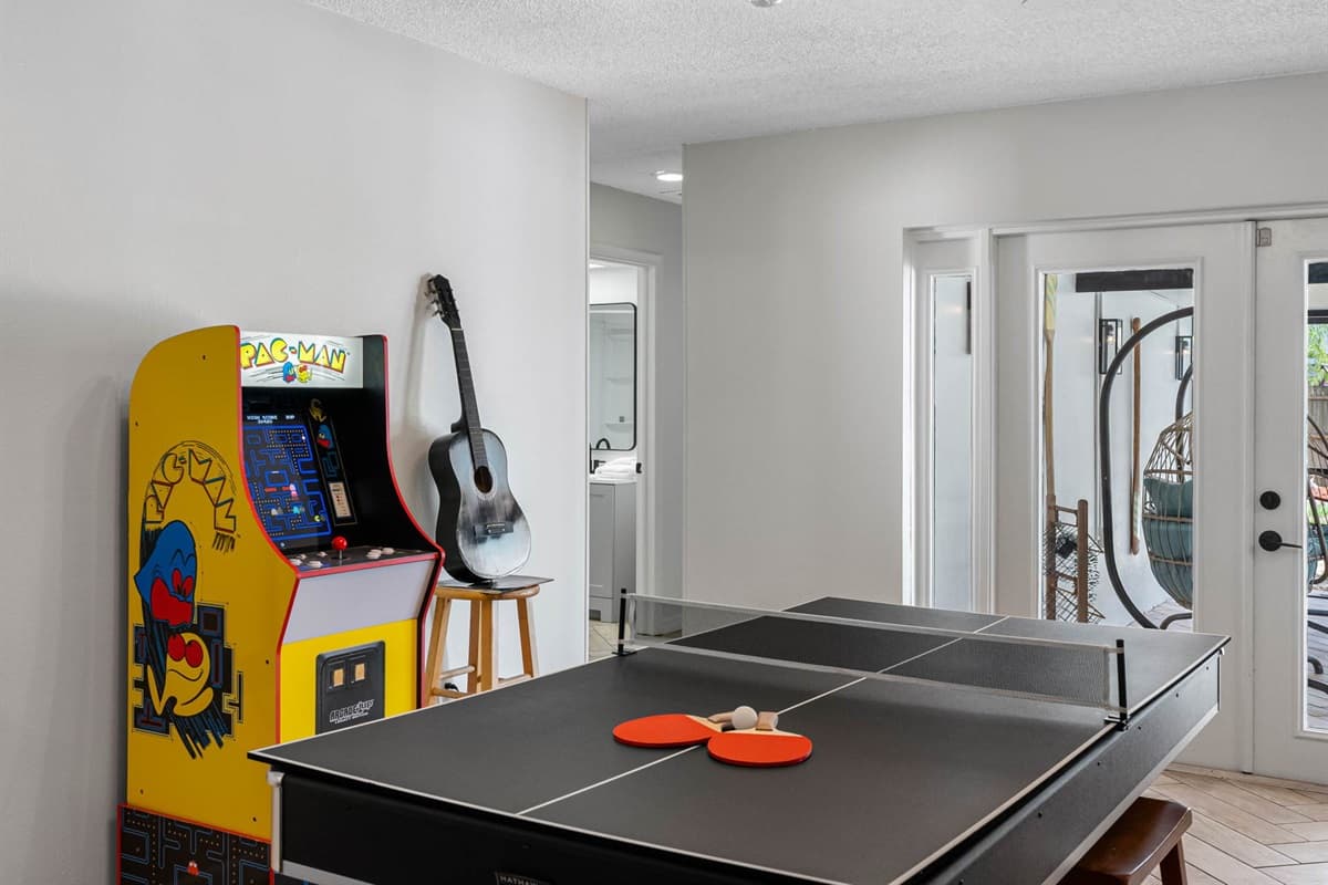 Step into your private arcade lounge with nostalgic touches like a classic Pac-Man machine, dartboard, and stylish bar setup—perfect for family game nights or late-night fun.