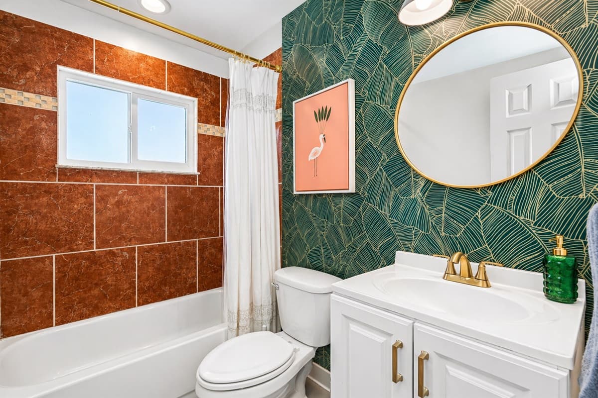 Stylish bathroom with vibrant tile, shower/tub combo, and modern vanity.