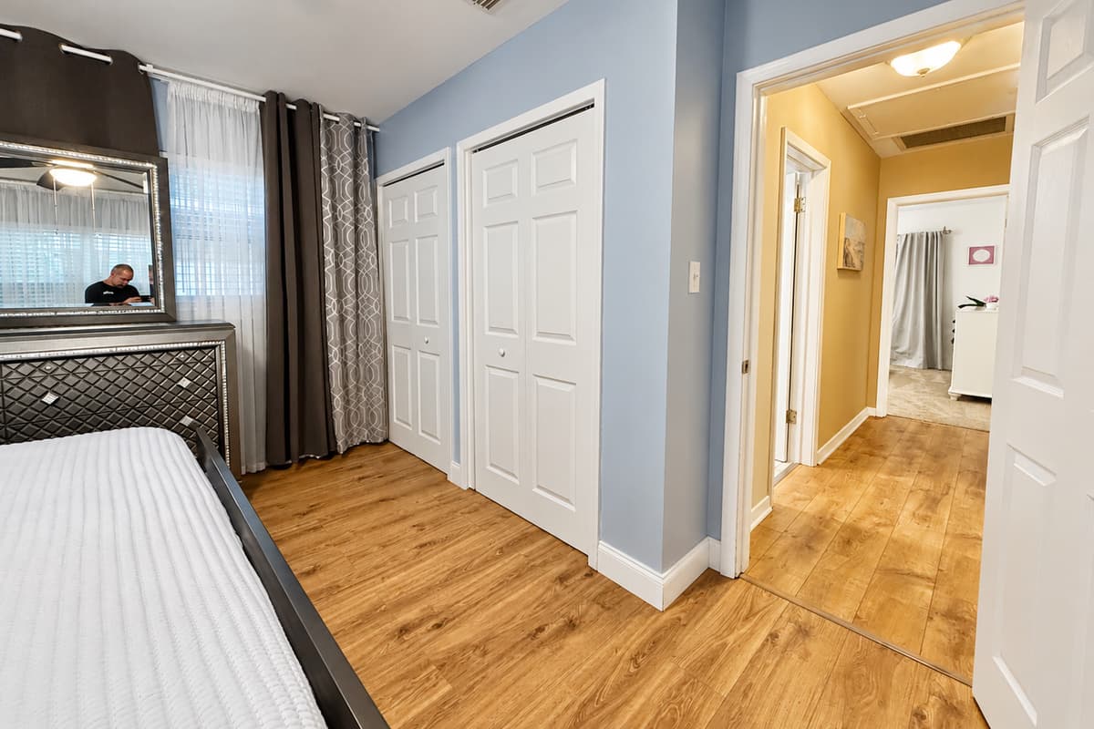 This bedroom shines with sophistication—boasting polished floors, sleek décor, and a cozy king bed.
