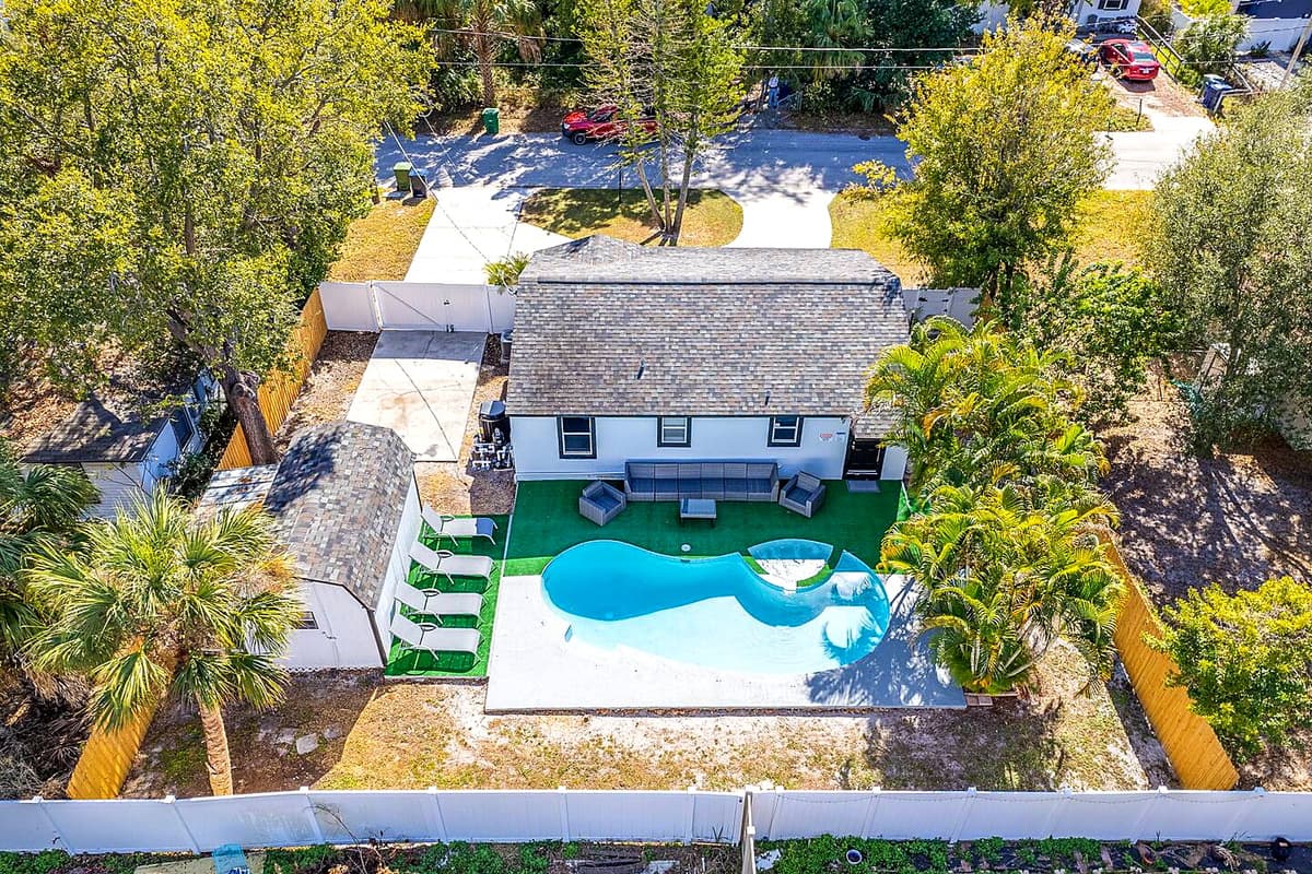 Aerial back view of our beautiful house showcasing our stunning heated pool. The property has some trees and has a fenced backyard. If you are interested in this property, send us an inquiry now!