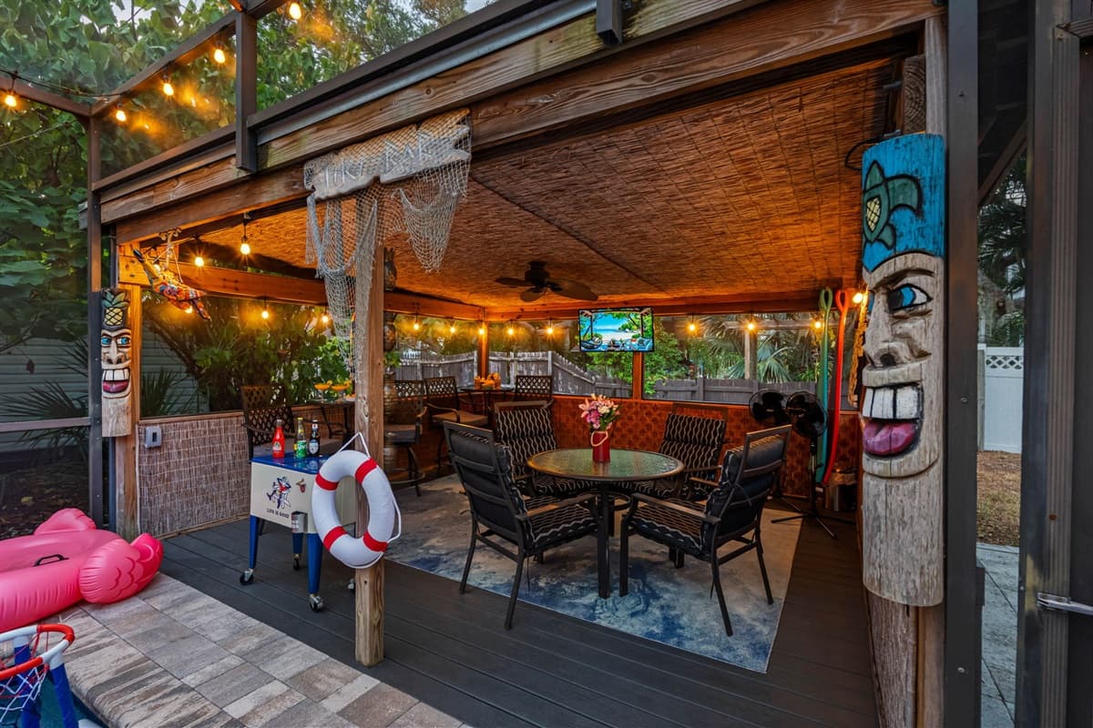 Relax and play in this spacious, covered patio that overlooks the pool area! With plenty of comfortable seating, fun tiki decorations, a TV for entertainment, and a shaded spot for snacks and drinks.