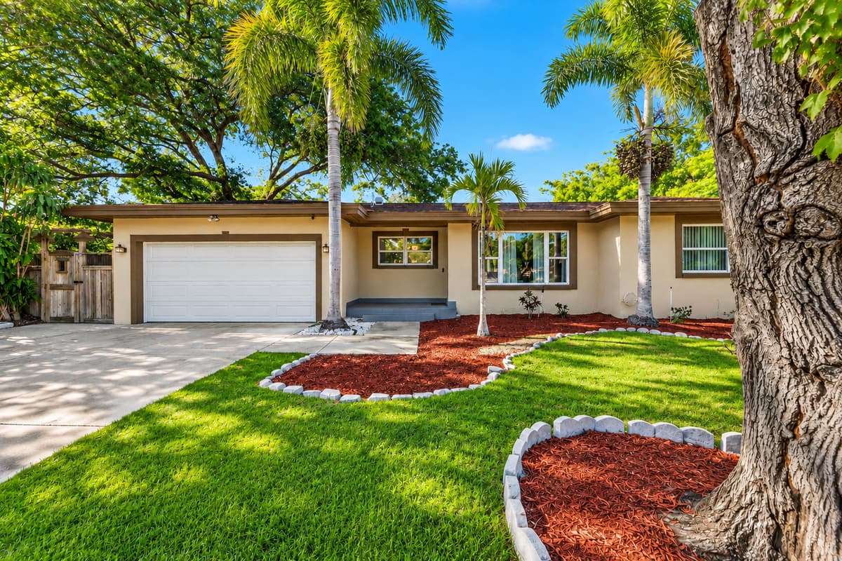 Beautiful exterior view featuring a large driveway, palm trees, and landscaped yard.