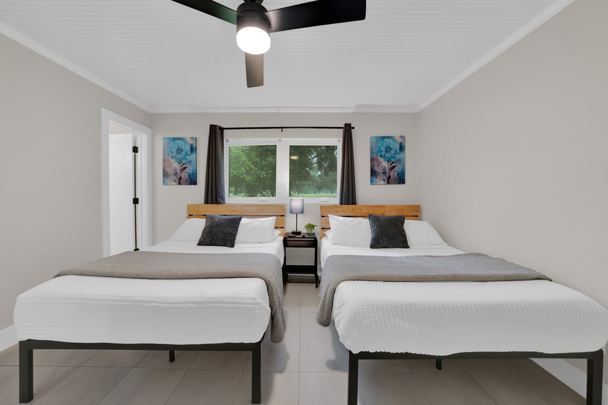 Wood headboards, gray throws, art that matches on both sides, simple, balanced, and easy to book with confidence.