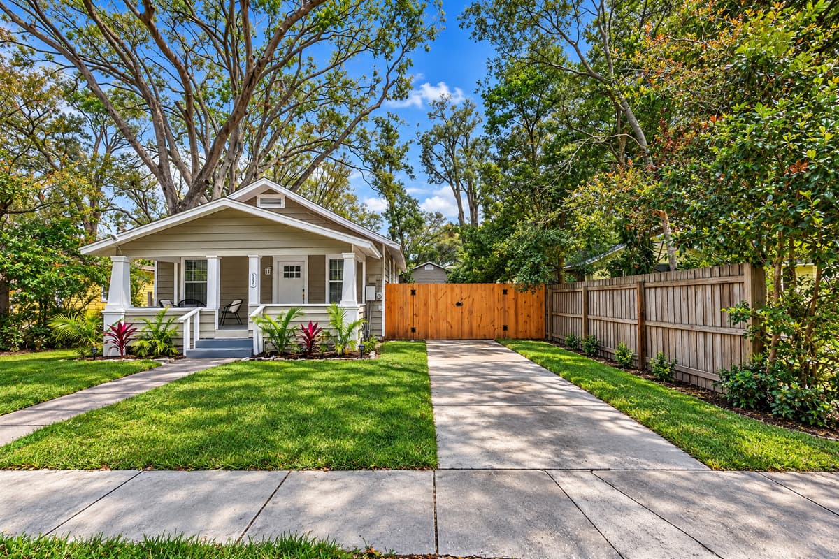 The fence runs the full length, so the yard is actually private. Grass, shade, room enough for a dog to run, and no neighbor's window looking in. The driveway feeds straight to the side door, which makes unloading groceries a thirty-second job.