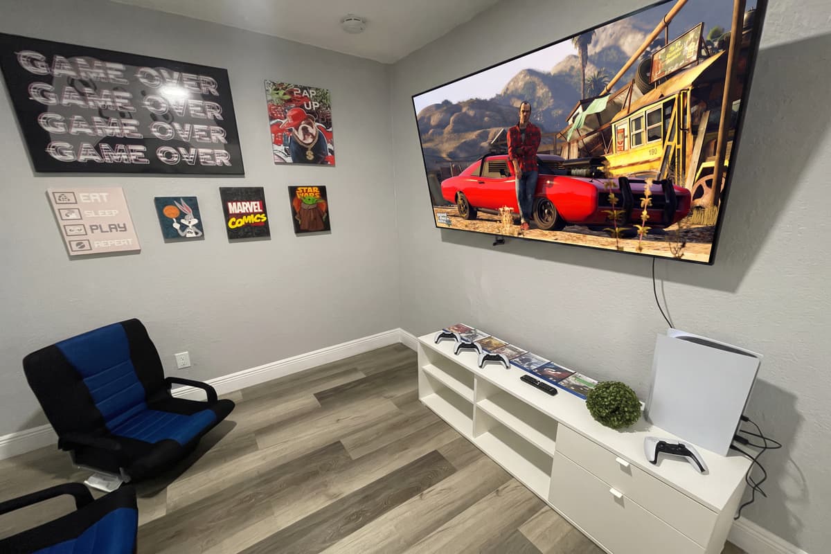 Surrounding the TV, a collection of comfortable and ergonomic chairs awaits, providing the perfect seating for extended gaming sessions.