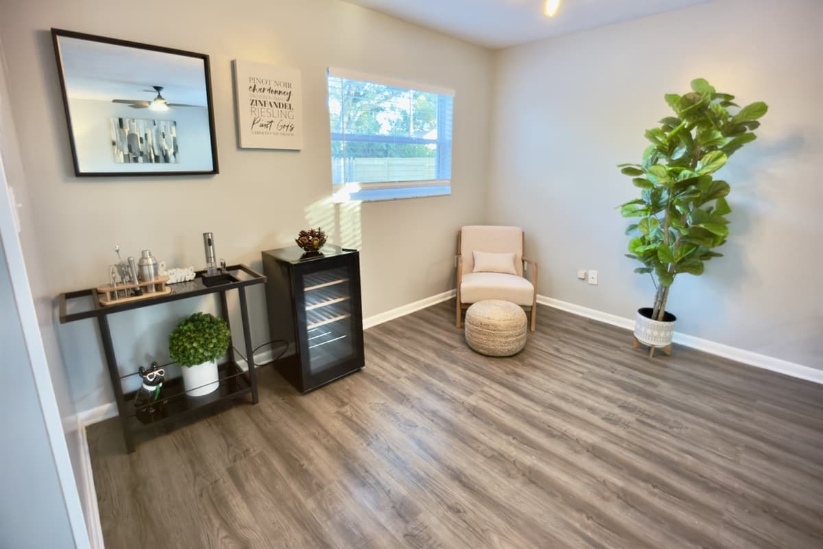 🌿 A chic sitting nook to unwind! Complete with a stylish bar cart, cozy accent chair, beautiful fiddle leaf fig tree, and tasteful art — the ideal corner to sip a drink and relax. 🍹✨