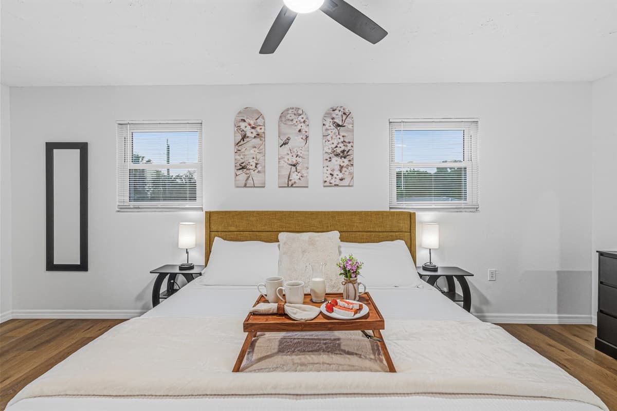 Elegant king bedroom with symmetrical design, soft lighting, and a peaceful atmosphere 
Tray and food setup shown are for staging purposes only and are not included.