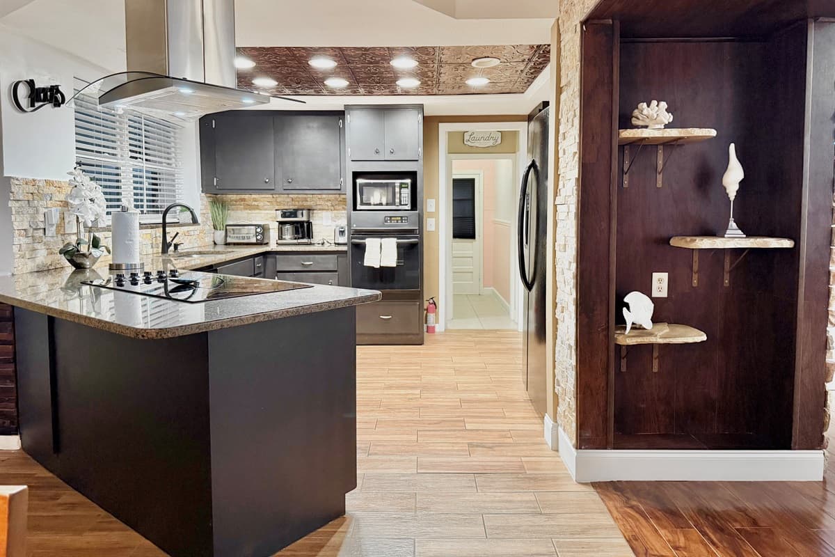 Simple yet elegant, this well-appointed kitchen combines modern appliances and rich wood tones with subtle backsplash details for a warm, welcoming feel.