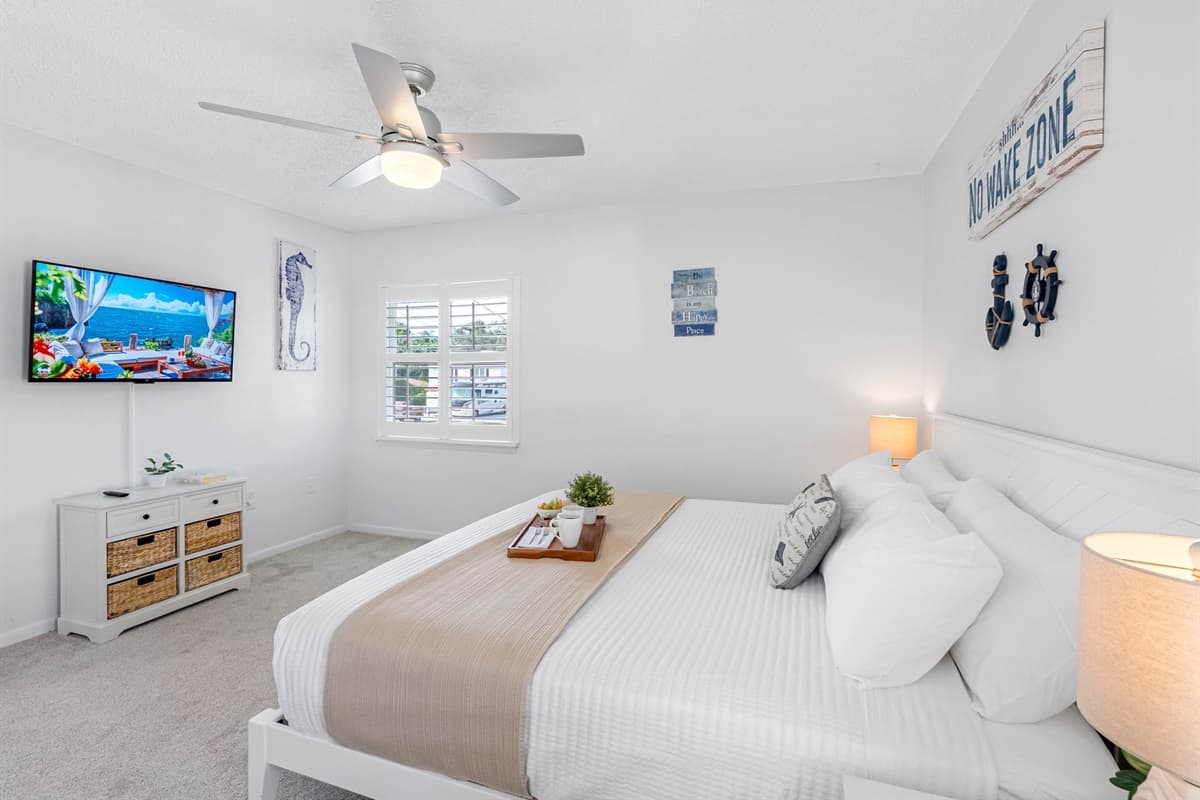 This primary suite offers a calming coastal vibe, perfect for unwinding after a beach day.