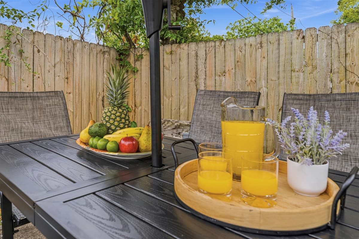 Close-up of outdoor dining setup with umbrella and fresh, inviting table setting.