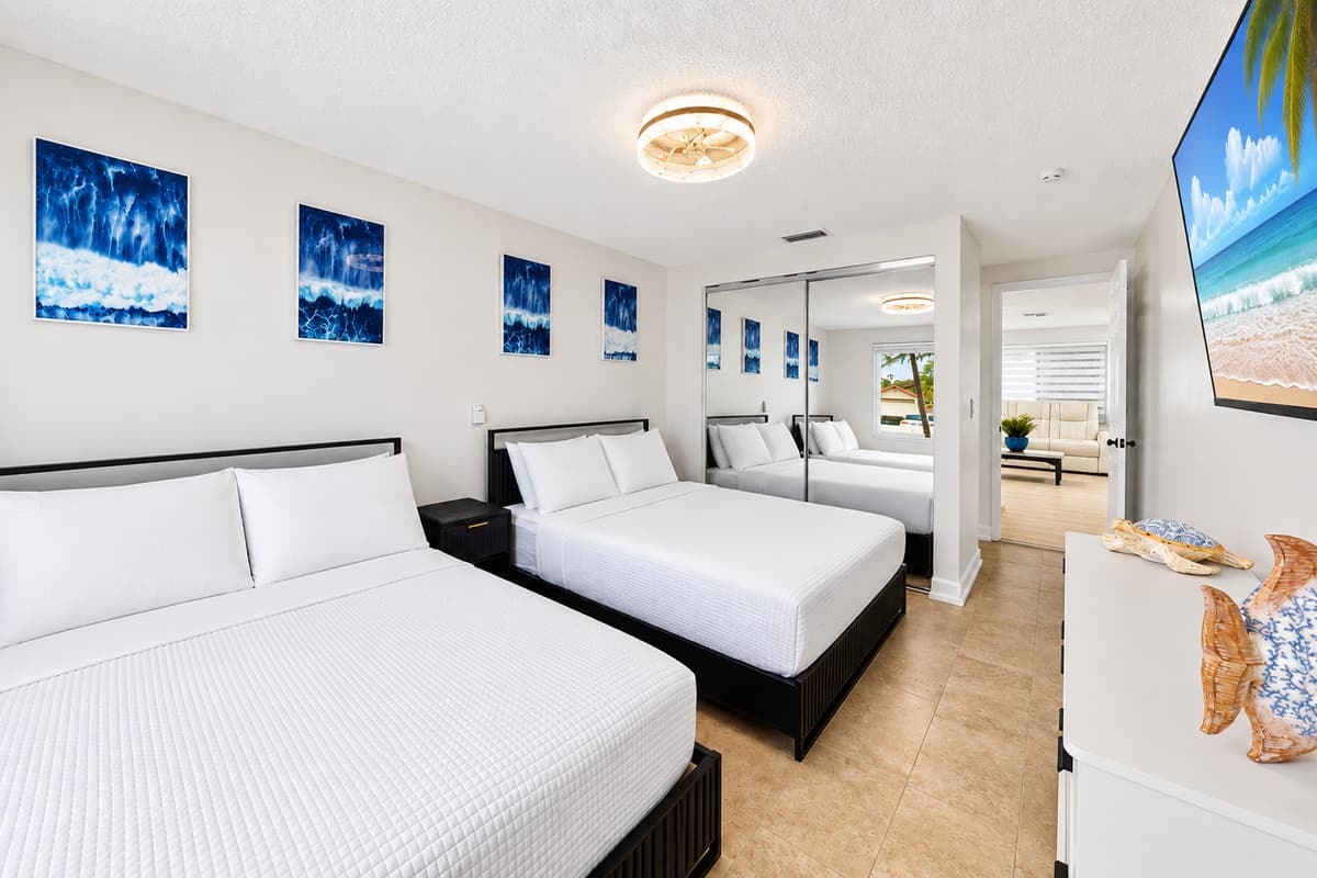 Flexible sleeping space with a king bed, a queen bed, modern furnishings, and easy access to nearby bathrooms.