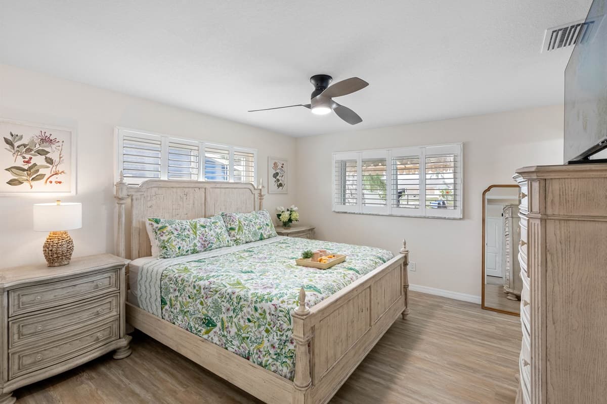 Soft green floral bedding and nature-inspired décor create a fresh, calming vibe, making this bedroom an ideal place to unwind.