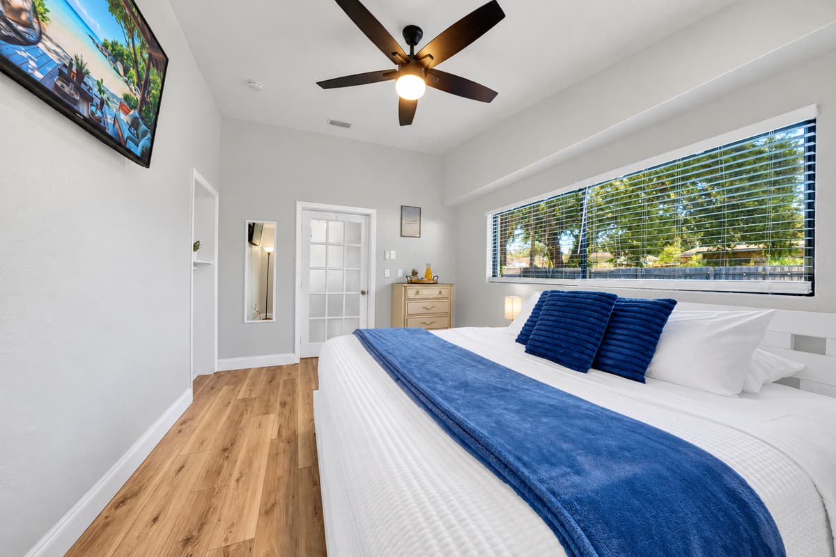 The king bed is where the beach day finally catches up with you. Fresh linens, ceiling fan turning, a Smart TV for whatever you fall asleep to, and blackout-quiet nights on a residential street with no traffic outside.