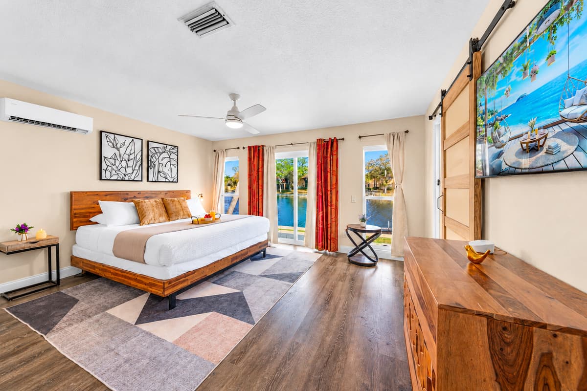 Relax in the spacious primary bedroom featuring a king bed and peaceful waterfront views.