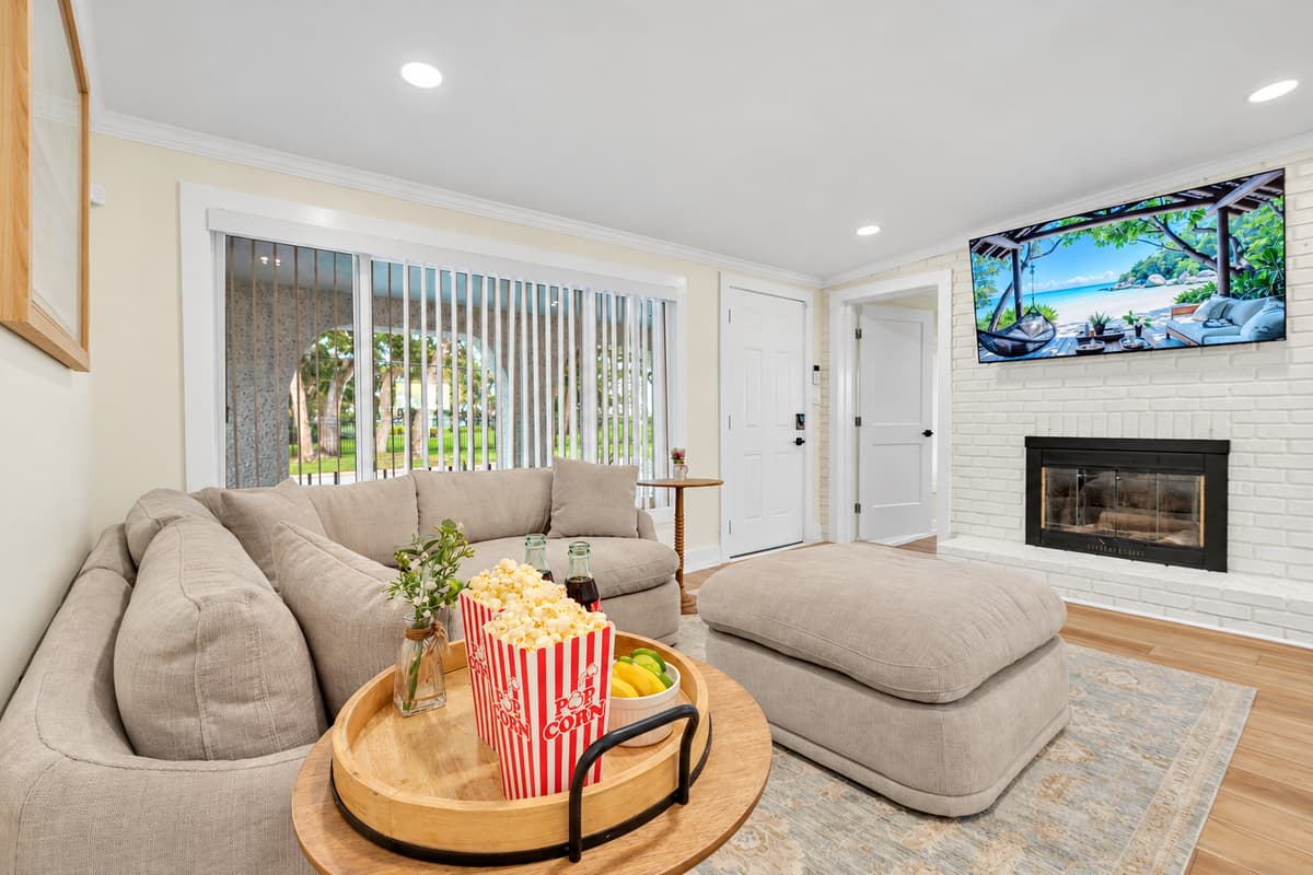 Fireplace, TV and popcorn night. The den has a fireplace, a wall-mounted TV and a curved sectional. Grab the popcorn and pick a movie.