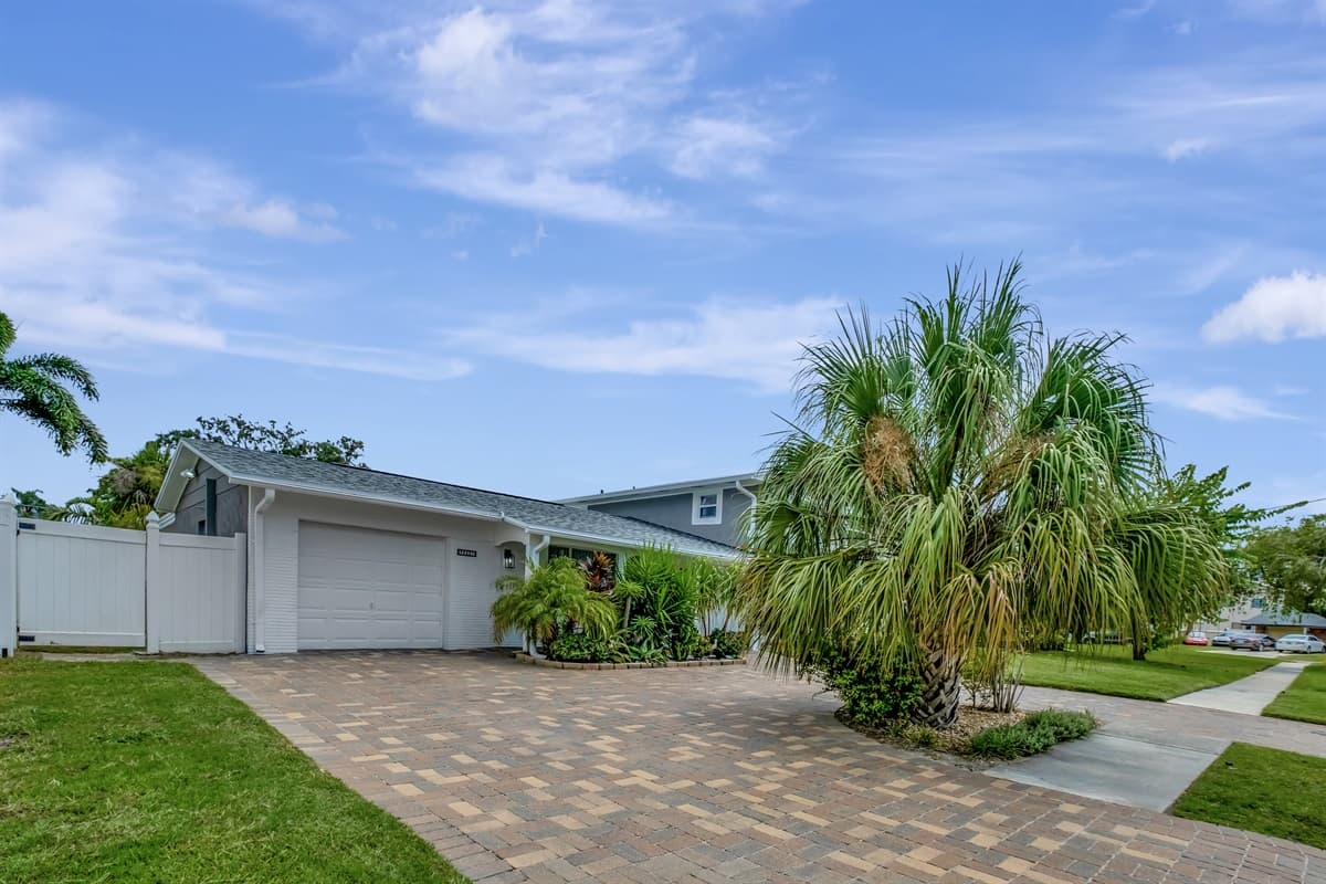 You'll be greeted by a spacious driveway that not only accommodates multiple vehicles but also adds a touch of grandeur to the entrance.