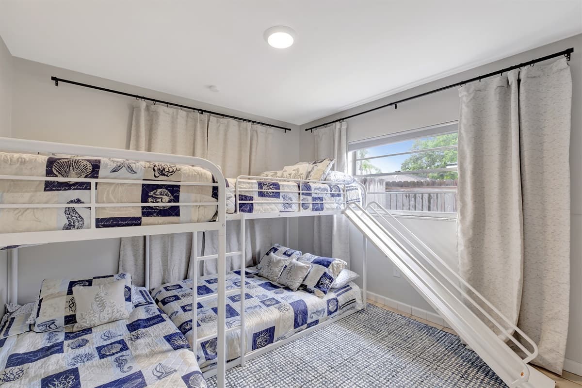 This whimsically themed room is a delight for children, complete with a bunk bed featuring a fun slide.