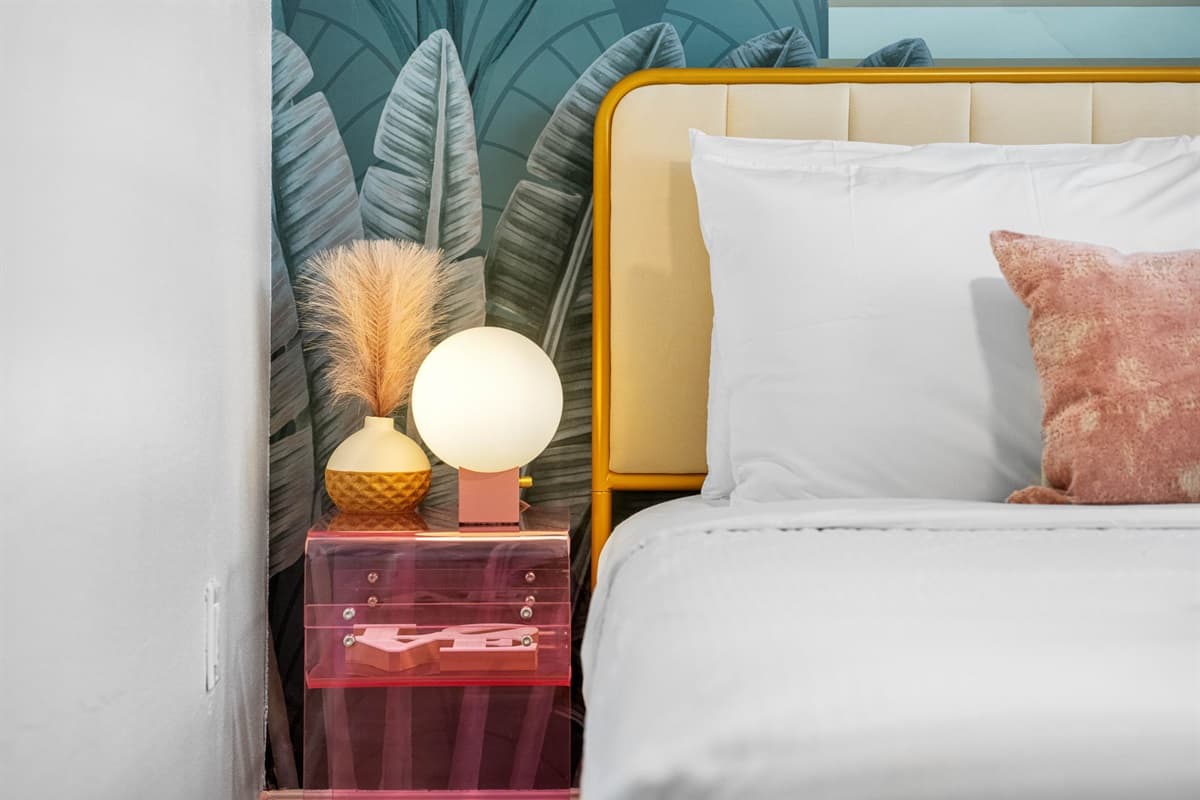 The bed is dressed in premium linens, featuring a plush duvet and a selection of pillows with varying firmness levels to guarantee a restful night's sleep.