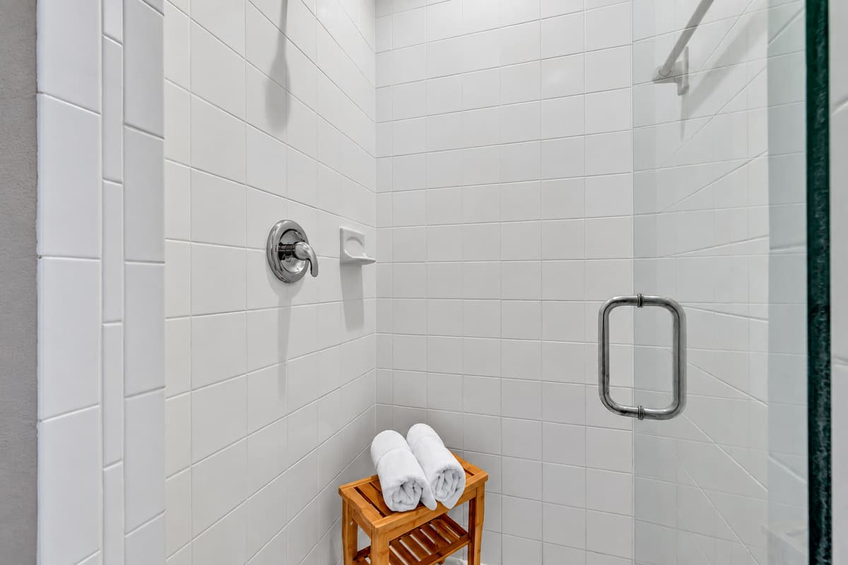 Adjacent to the bathtub, a walk-in shower stands ready to envelop you in a cascade of warm water, washing away the stresses of the day.