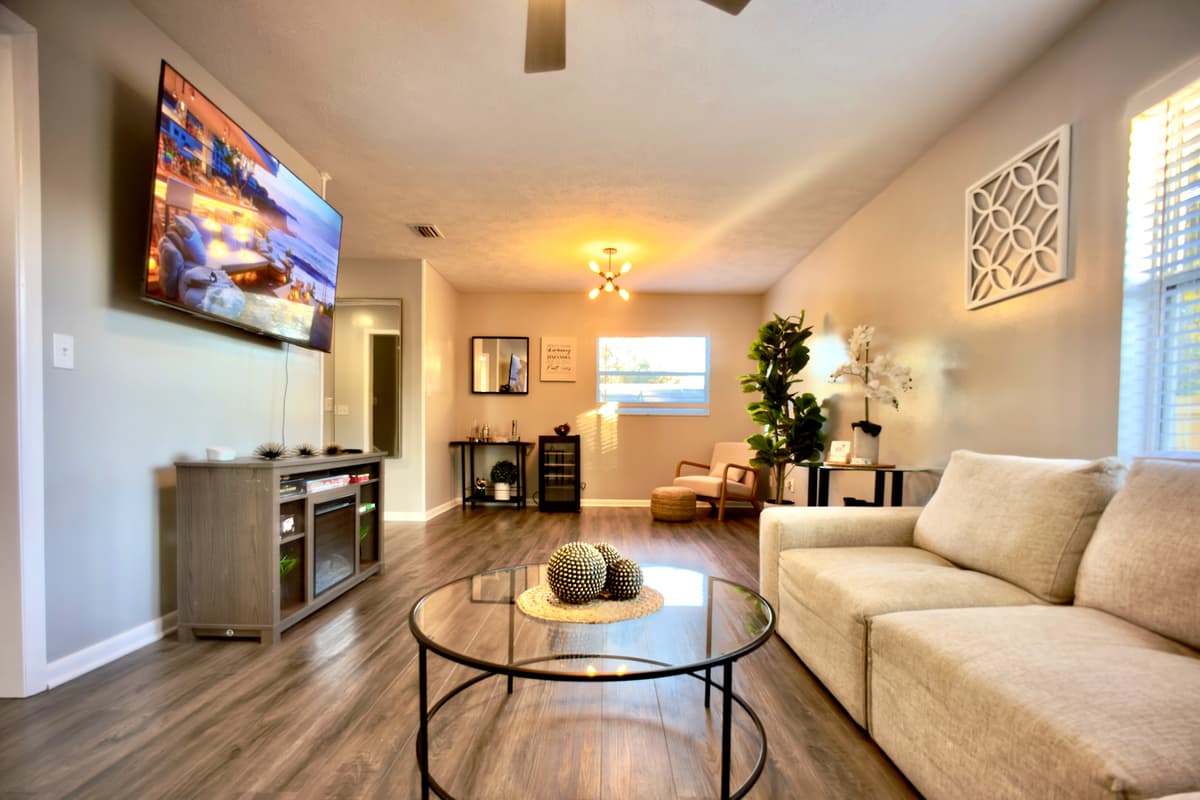 📺 The open-concept living area is designed for quality time together! Featuring a massive smart TV, stylish entertainment center, comfy sofa, and chic décor — your perfect gathering space. ✨🏠