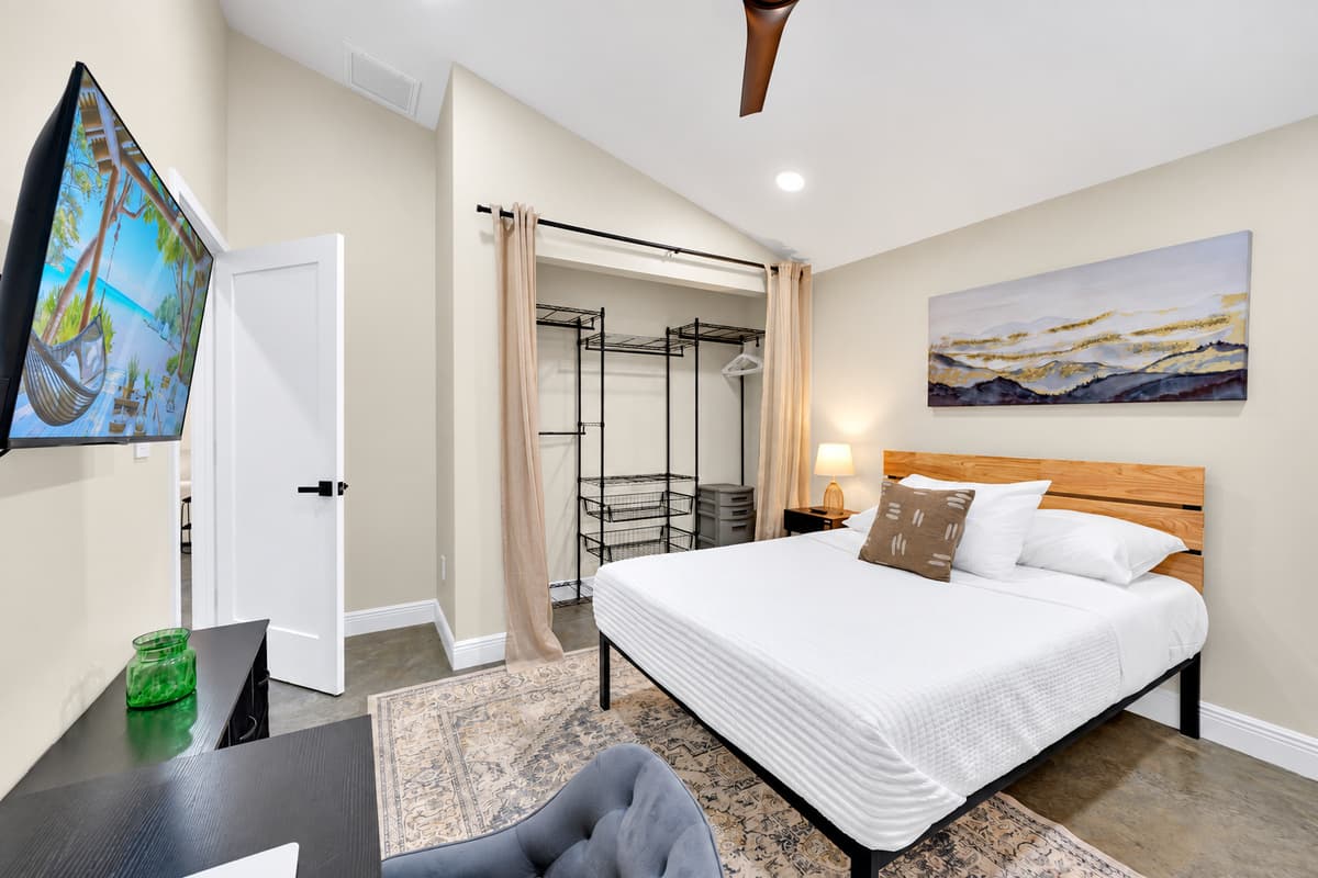 Unpack once. Stay as long as you like. Comfortable king bed, built-in storage behind the door and a screen at the foot of the bed, in a room designed for stays measured in weeks, not nights.