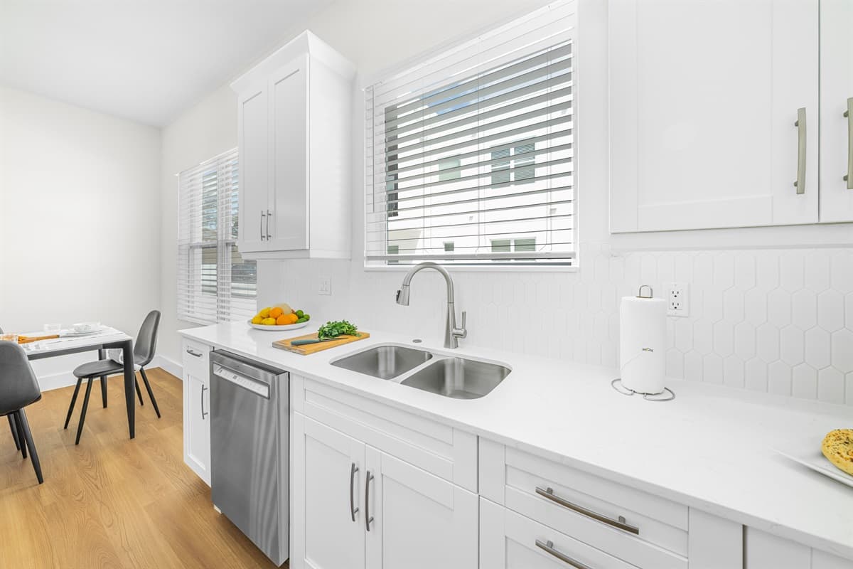 Bright, modern kitchen with crisp white countertops, ample cabinet space, and stainless steel appliances.