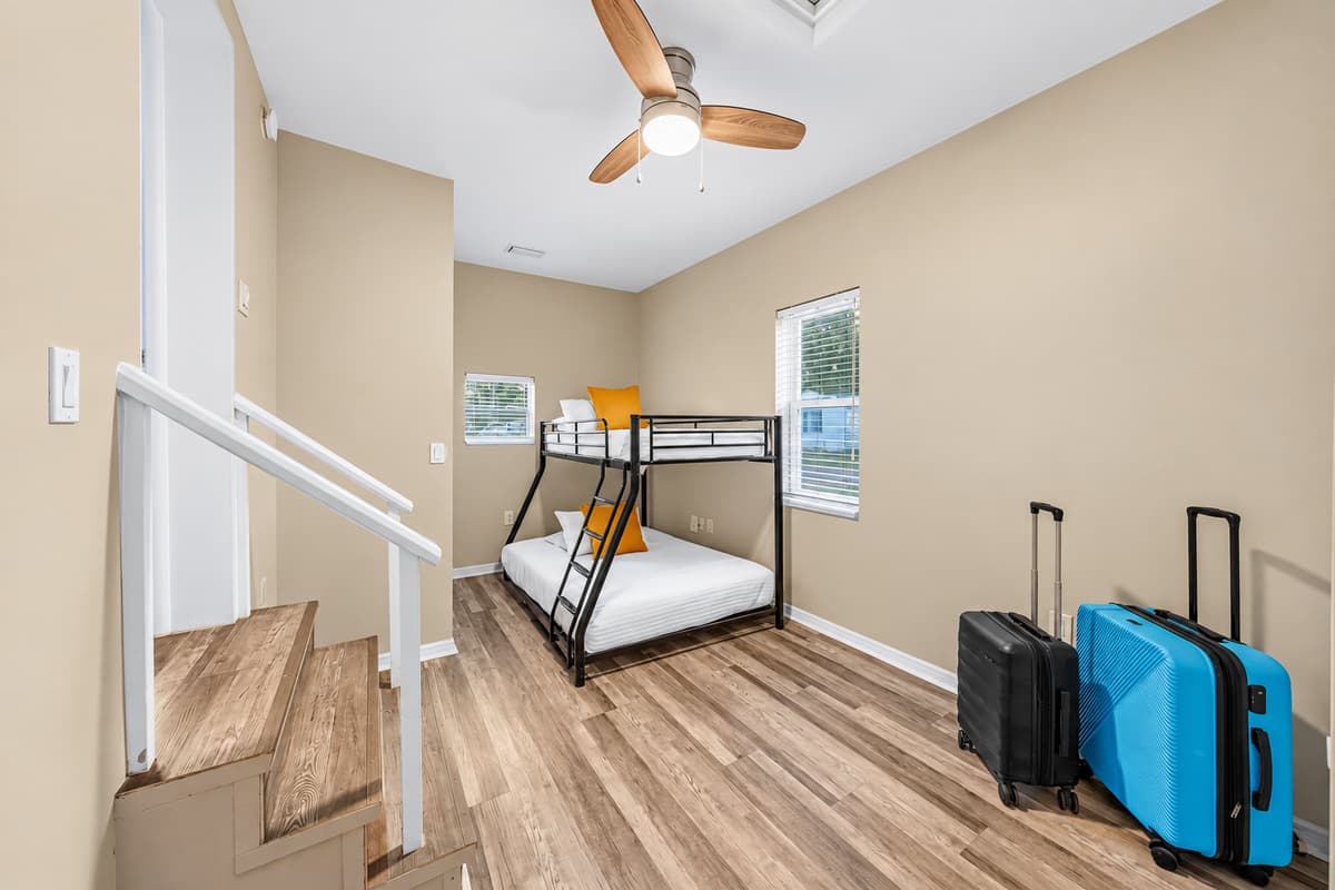 Bright bunk room with multiple beds and luggage space—ideal for larger groups or families.