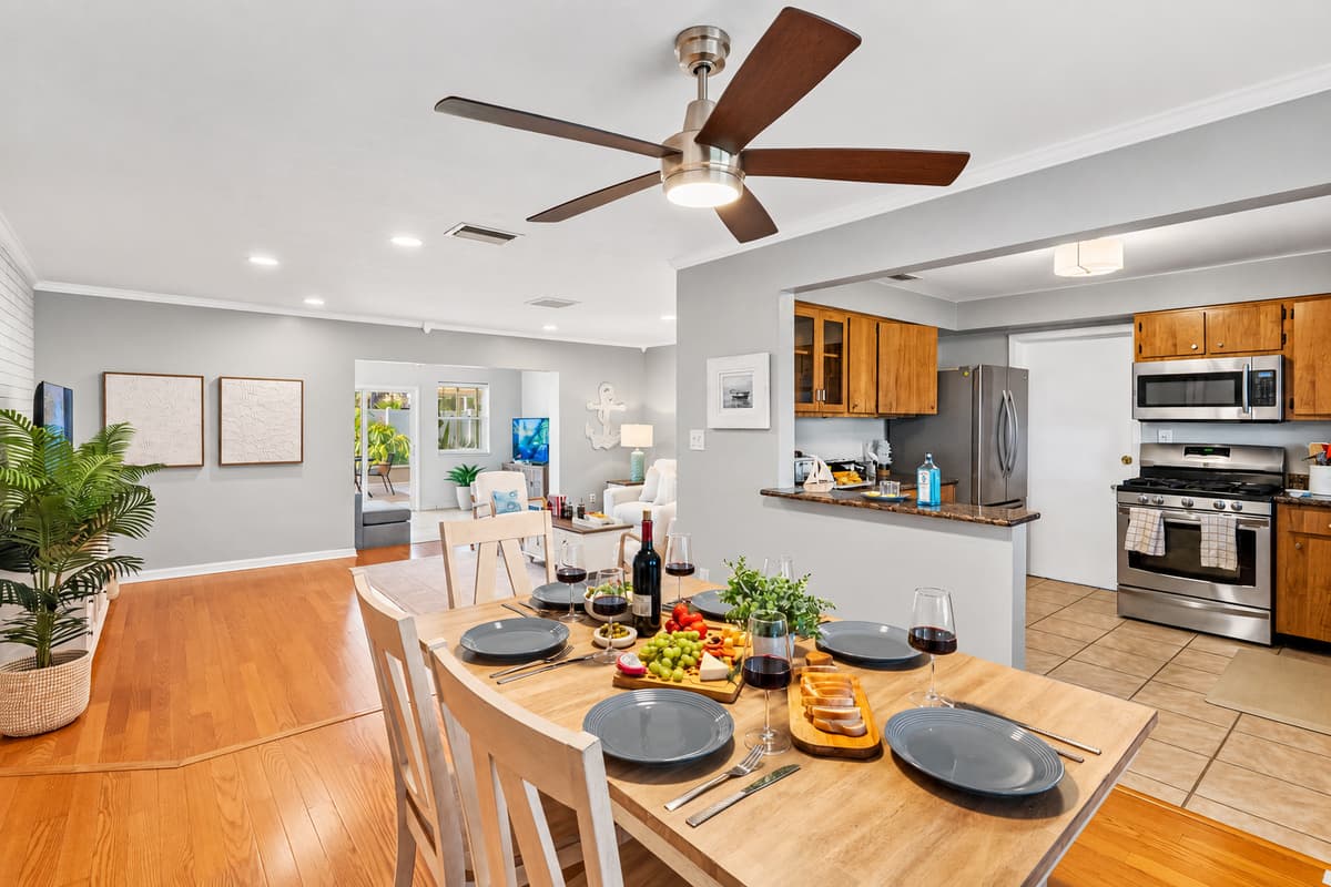 Tucked between a cozy living area and a fully stocked kitchen, this welcoming dining setup blends convenience and charm—ideal for anything from family dinners to celebratory toasts.