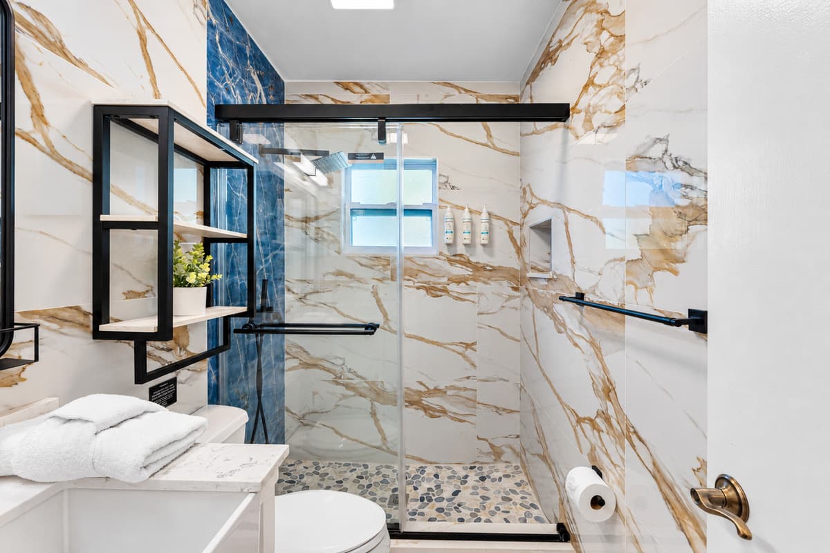 Soft tones, updated lighting, and a touch of greenery make this bathroom feel fresh and inviting.
