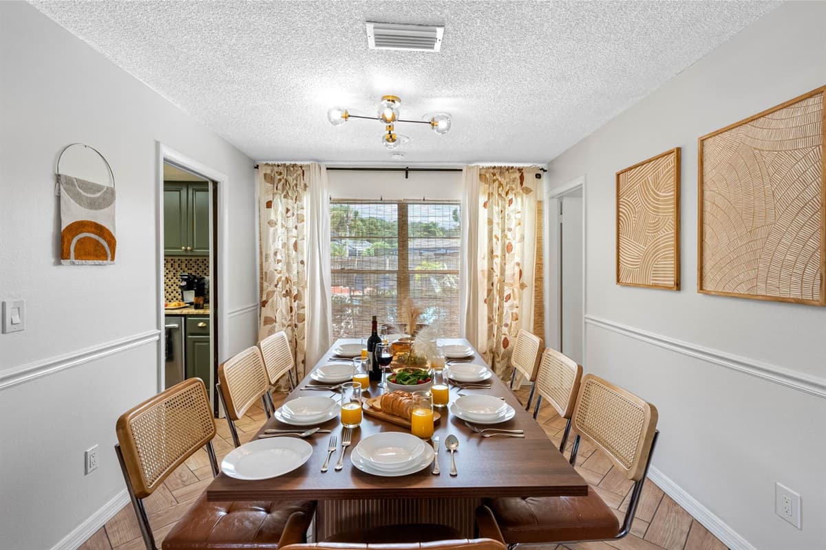 Sunlight pours through large windows to illuminate this airy dining space. The stylish table seats eight and offers a welcoming environment for group meals, takeout spreads, or a cozy dinner in.