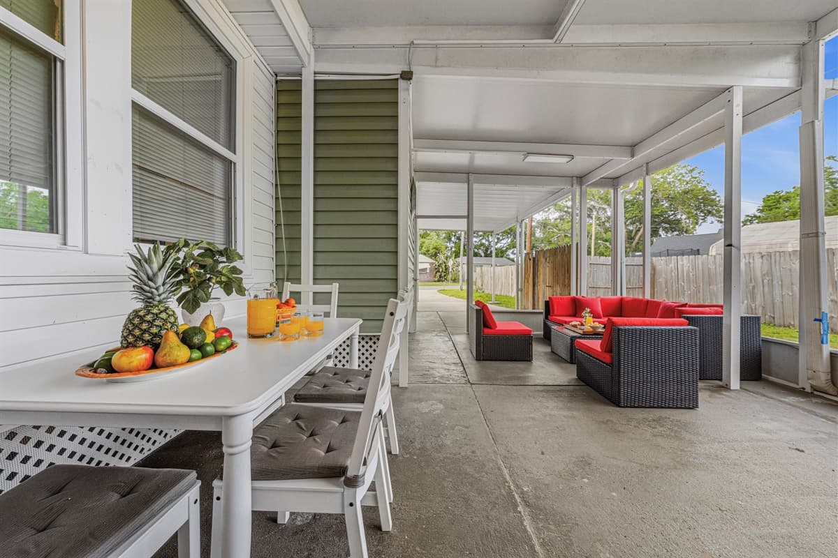 Covered outdoor lounge with dining table and seating—perfect for relaxing or enjoying meals outside.