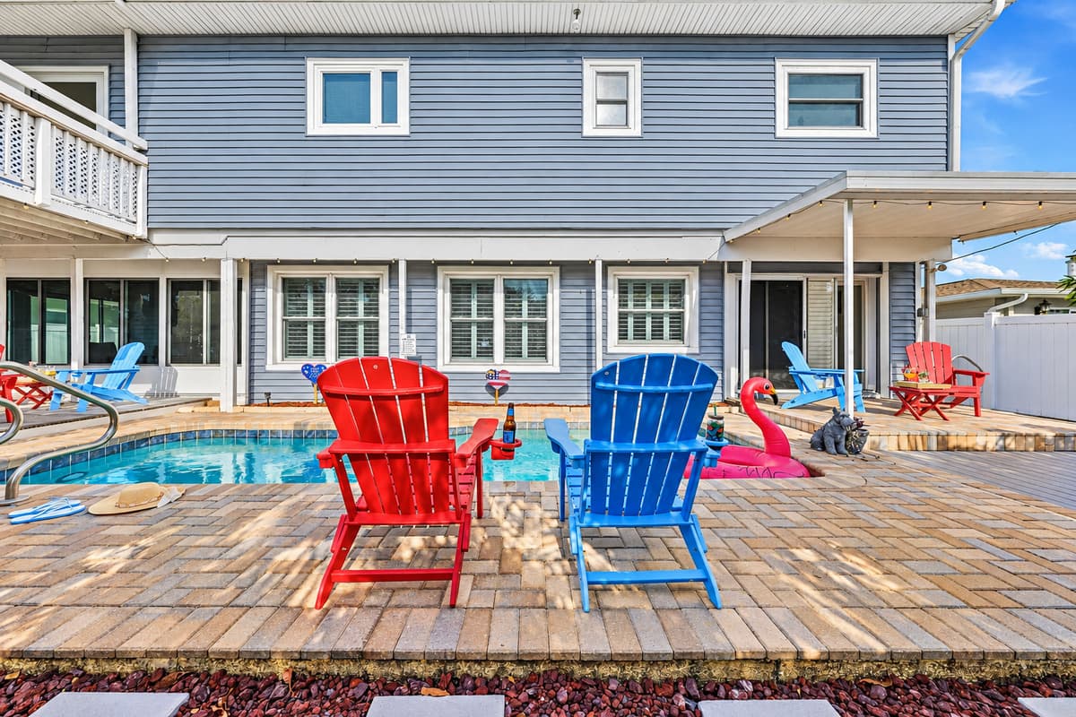 Wide view of the backyard oasis featuring pool, seating, and plenty of space for everyone to enjoy 