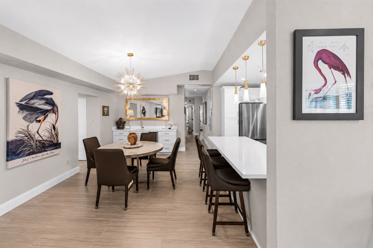 Open-concept dining and kitchen area featuring modern finishes, elegant lighting, and spacious seating.