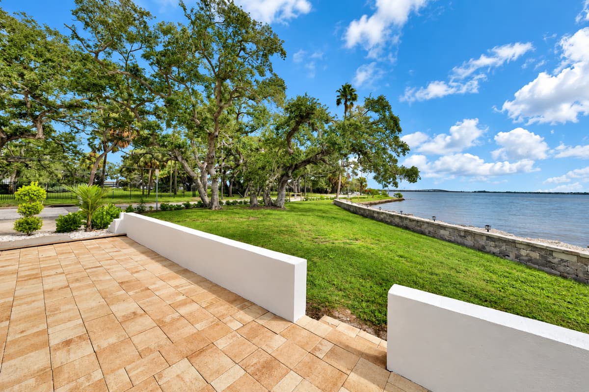 Room to breathe by the water. The paver patio and lawn open toward the bay and old oaks. Space to stretch out and soak up the Florida sun.