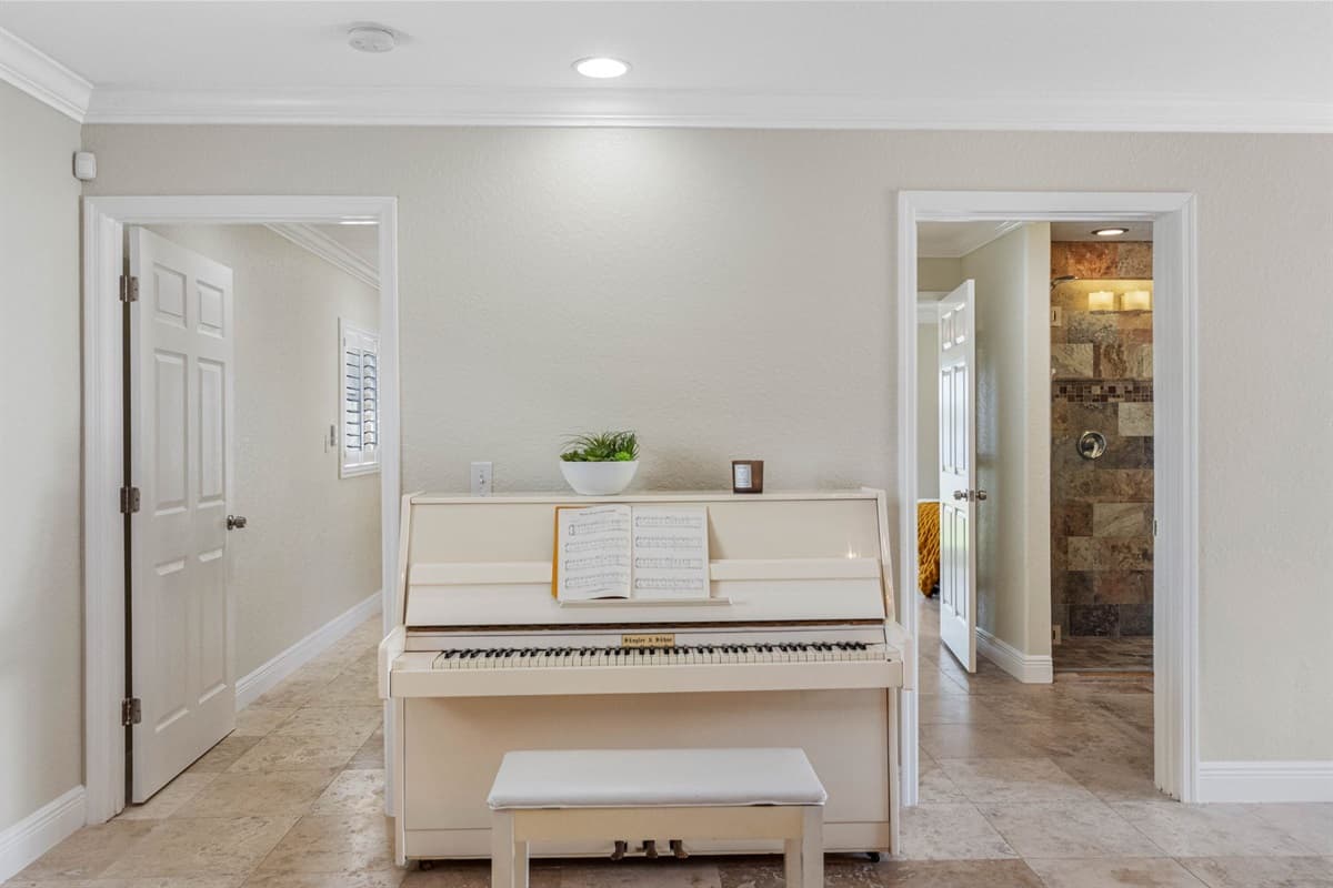 This inviting space features a white upright piano and matching bench, ready for a relaxing play session.