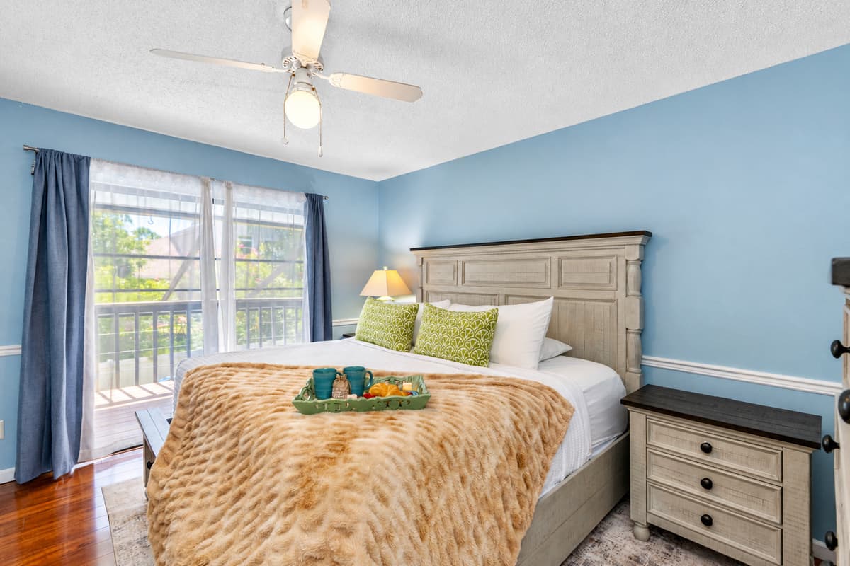 This inviting bedroom features soft blue walls, a comfortable king-size bed, and a calming atmosphere—perfect for a restful night's sleep.