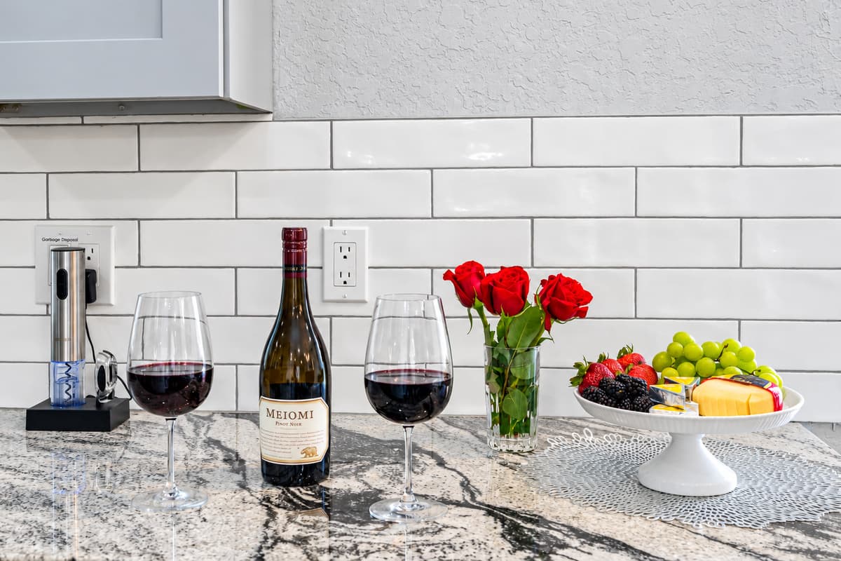 A welcome toast on the counter. Wine glasses ready, fresh fruit, and granite countertops. Small touches that make the first evening of your trip feel special.