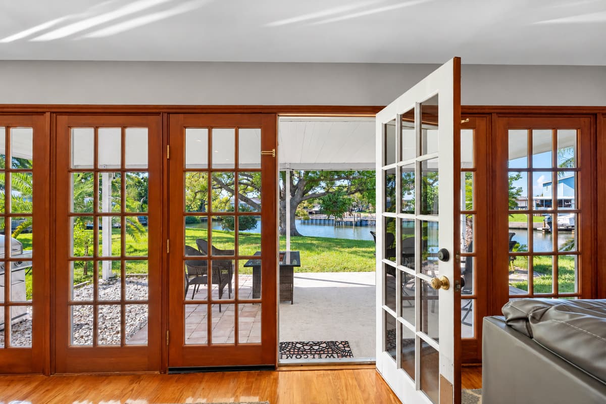 The expansive wall of French doors seamlessly connects the indoors to the outdoors, inviting greenery and sunlight into the heart of the home.