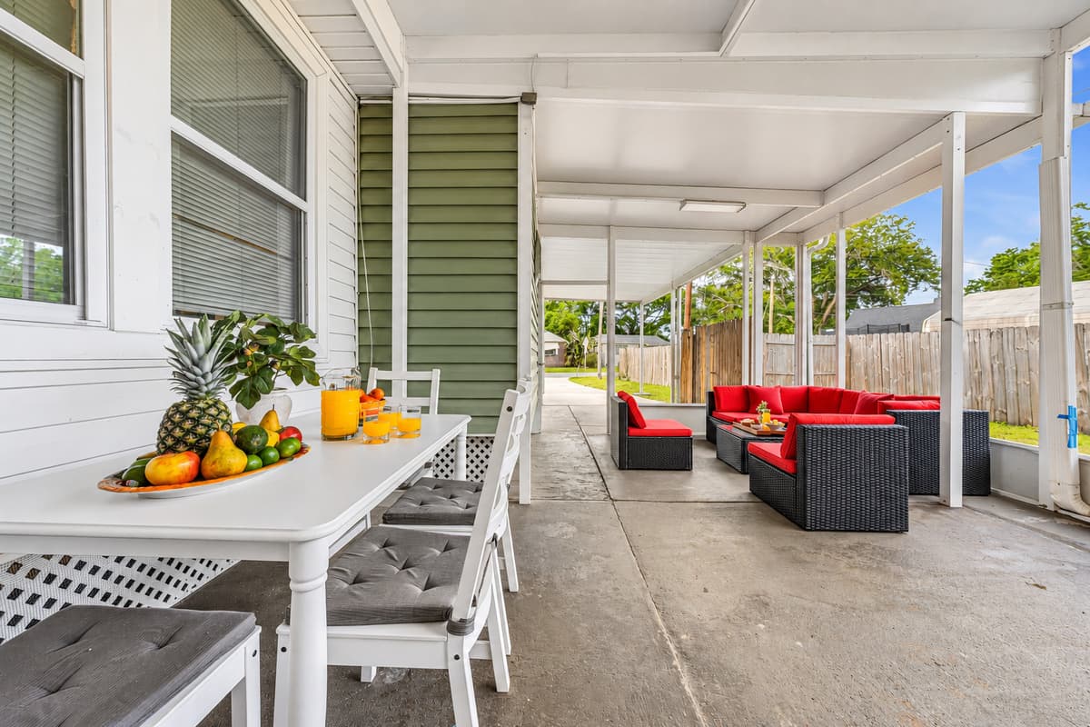 Covered outdoor lounge with dining table and seating—perfect for relaxing or enjoying meals outside.