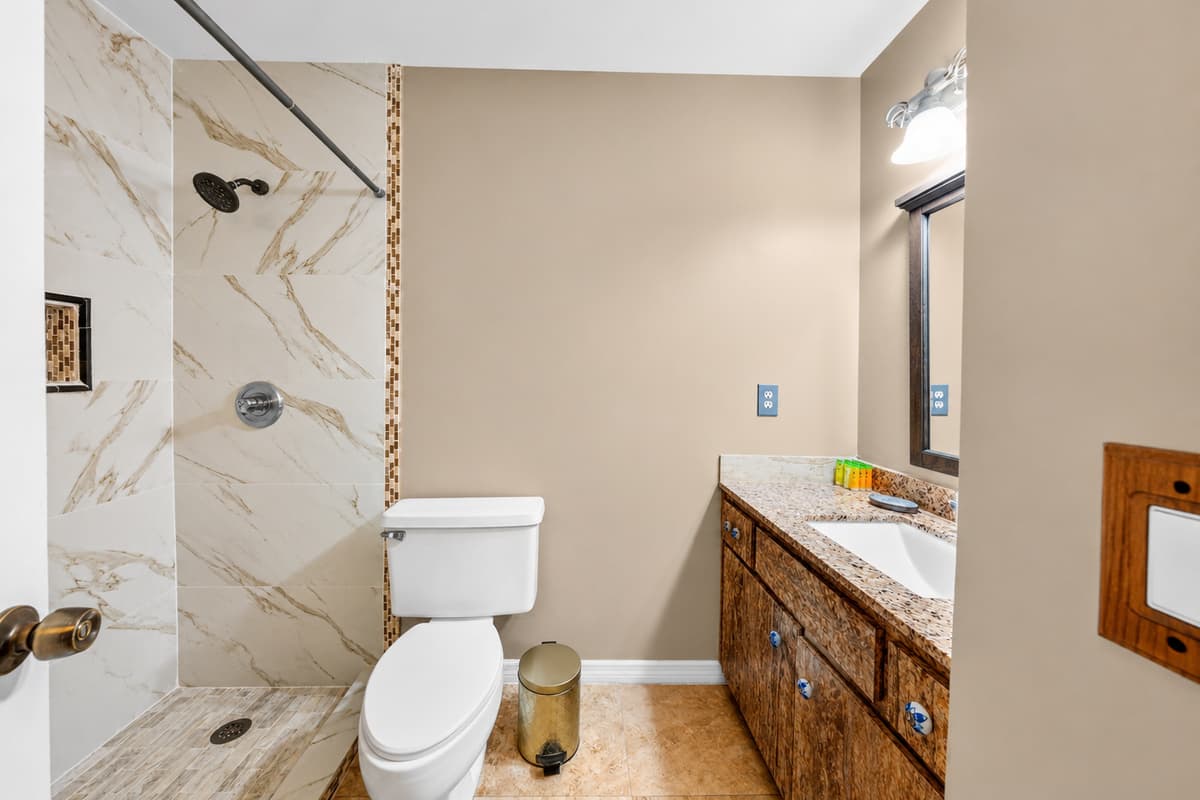 Spacious bathroom with a large vanity, shower, and plenty of room for guests to get ready.