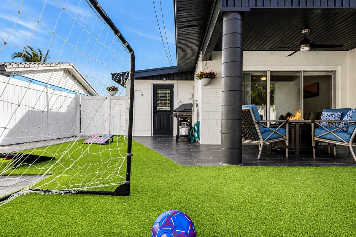 Cozy covered patio with outdoor dining, lounge seating, and backyard play area.