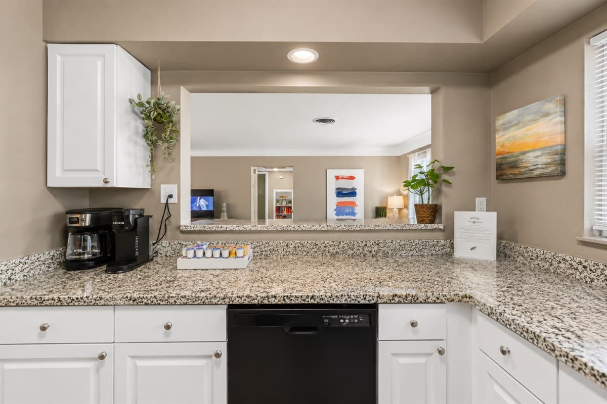 Bright and functional kitchen with granite countertops, coffee station, and open-concept design.