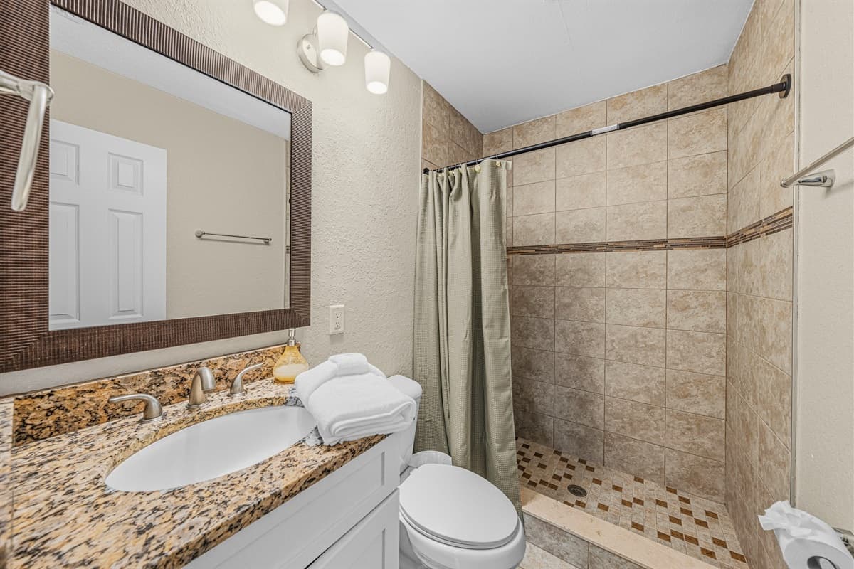 Stylish bathroom with tiled walk-in shower and modern finishes.