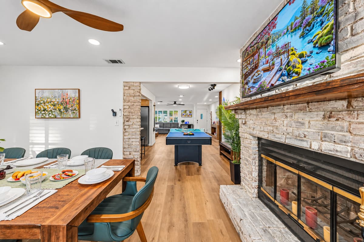 Dining area with a stunning fireplace feature and open view into the game space—great for entertaining 