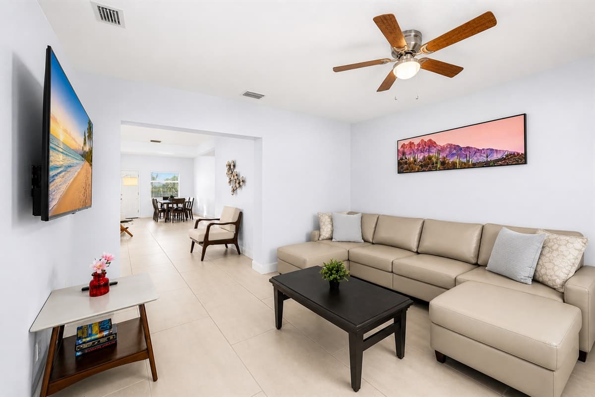 Bright and spacious living room featuring a large sectional sofa, smart TV, and open-concept layout.