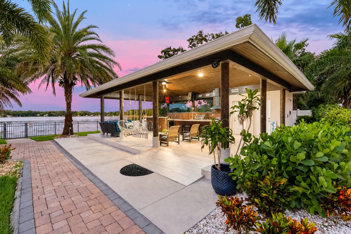 This expansive covered patio offers bar seating, hanging chairs, and lounge areas, all with stunning waterfront views.
