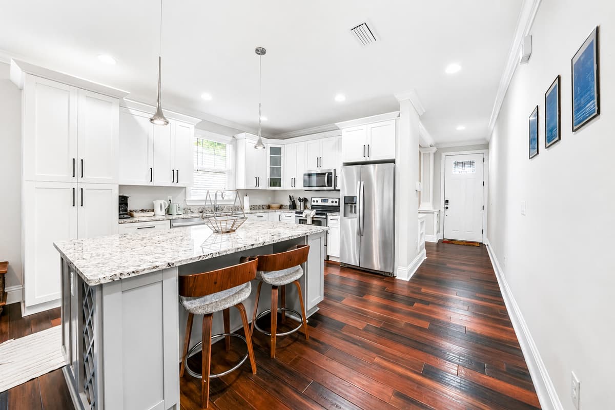 Cook with ease in the modern kitchen featuring granite countertops, stainless steel appliances, and bar seating.