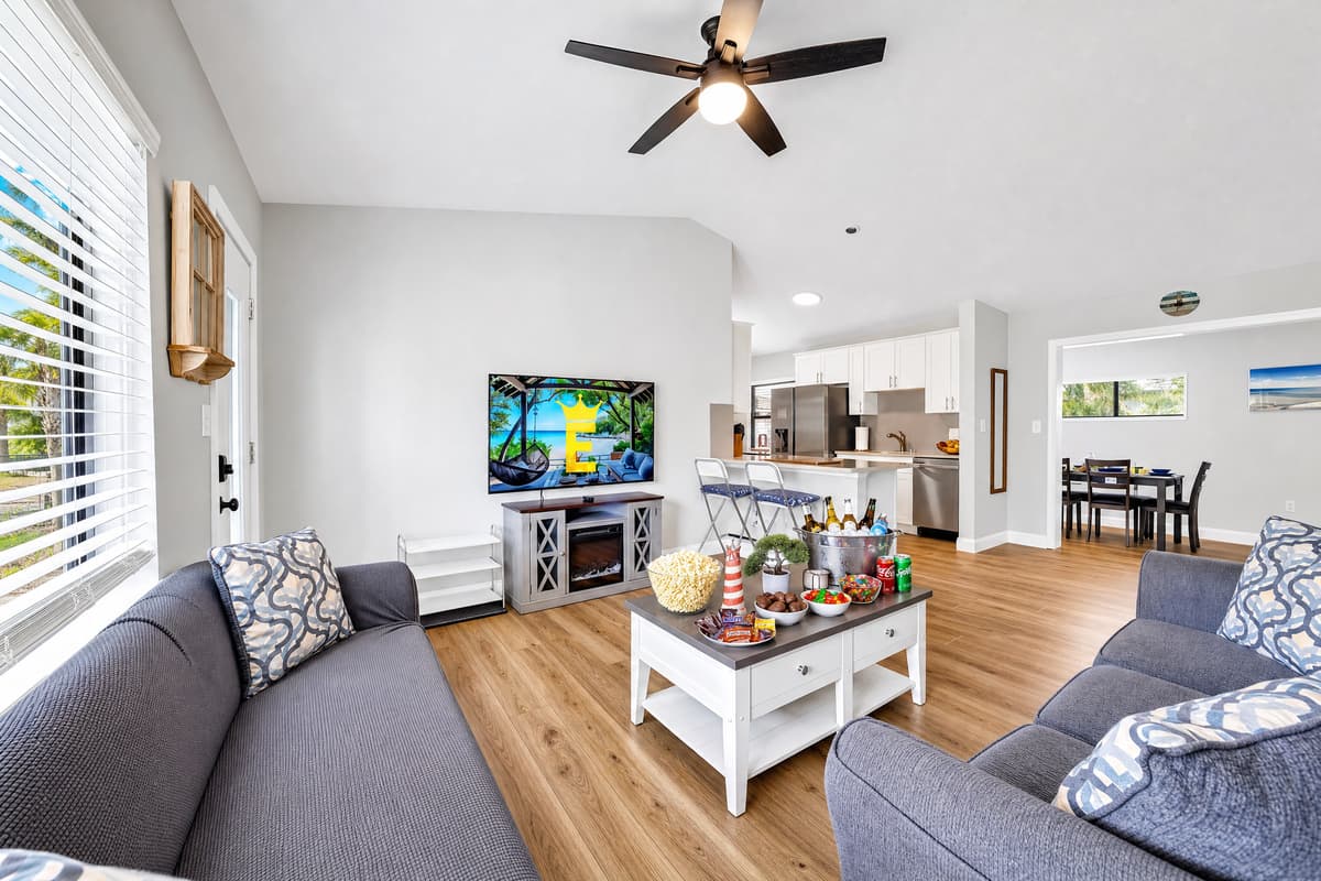 An open living room where everything happens, sectional seating for the whole group, a large TV, and a bright layout that flows straight into the kitchen and dining area, so nobody gets left out of the conversation.